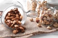 Overturned glass jars with different nuts on table Royalty Free Stock Photo