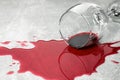 Overturned glass with red wine spill on grey table, closeup Royalty Free Stock Photo