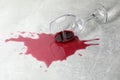 Overturned glass with red wine spill on grey table Royalty Free Stock Photo