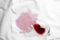 Overturned glass and spilled exquisite red wine on shirt, top view. Space for text Royalty Free Stock Photo