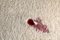 Overturned glass and spilled exquisite red wine on soft carpet Royalty Free Stock Photo