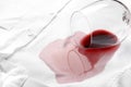 Overturned glass and spilled exquisite red wine on white shirt