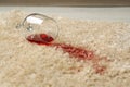 Overturned glass and spilled red wine on soft carpet, closeup Royalty Free Stock Photo