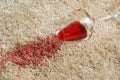 Overturned glass and spilled red wine on soft carpet, closeup Royalty Free Stock Photo