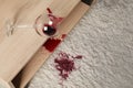 Overturned glass and spilled red wine on white carpet indoors, above view Royalty Free Stock Photo