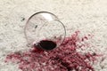 Overturned glass and spilled red wine on white carpet, closeup Royalty Free Stock Photo