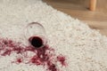 Overturned glass and spilled red wine on white carpet, space for text Royalty Free Stock Photo