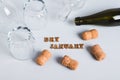 Overturned glasses, empty bottles, corks and text dry january on gray background Royalty Free Stock Photo