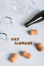 Overturned glasses, empty bottles, corks and text dry january on gray vertical view Royalty Free Stock Photo