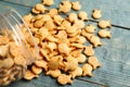 Overturned jar with goldfish crackers on blue wooden table