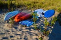 Overturned multi-colored Kayaks Cover the Sand