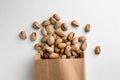 Overturned paper bag with pistachio nuts on white background, flat lay Royalty Free Stock Photo