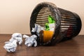Overturned trash can with crumpled paper balls and disposable cups Royalty Free Stock Photo