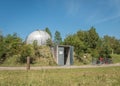 small observatory surrounded by trees and with a blue sky
