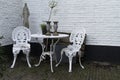 Overview of beautiful, vintage style wrought iron garden seats and table on a patio