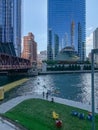 Overview of Chicago Loop recreation park where kayaks cross river, tourists walk riverwalk and relax on colorful chairs