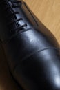 Overview detail of a black leather classic shoe on a wooden dance floor