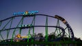 Overview of the mobile roller coaster "Alpina Bahn" at a funfair at night with illuminated train Royalty Free Stock Photo