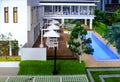 Overview of modern contemporary miniature model of luxury housing with swimming pool and deck chairs. Focus on the pool deck