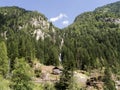Overview of the refuge in Daone Valley under the waterfall among the fir trees of the mountains of Trentino, Italy