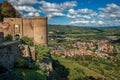 Overview of stone tower, green hills, vineyards and town rooftops near a road. From the city center of Orvieto. Royalty Free Stock Photo