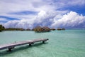 Overwater bungalows stretching and a wooden bridge out across the lagoon in Bora Bora island