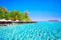 Overwater bungalows on tropical island with sandy beach, palm trees and beautiful lagoon Royalty Free Stock Photo