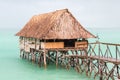 Overwater thatched roof bungalow hut of Micronesian people, lagoon of South Tarawa, heavy rain shower, wet season, Kiribati, Royalty Free Stock Photo