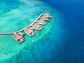 Overwater villas on tropical atoll island for holidays vacation travel and honeymoon. Luxury resort hotel in Maldives or Caribbean Royalty Free Stock Photo