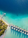 Overwater villas and white sand beach on tropical island for holidays vacation travel and honeymoon. Luxury resort hotel in Royalty Free Stock Photo