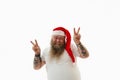 An overweigh handsome man in Santa Claus hat doing positive gesture with hands, pointing two fingers up, showing a peace sign Royalty Free Stock Photo