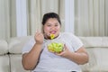 Overweight Asian woman eats vegetables salad