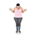 Overweight Asian woman looking shocked to see the weight on the scale isolated on white background Royalty Free Stock Photo