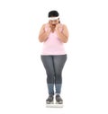 Overweight Asian woman looking shocked to see the weight on the scale isolated on white background Royalty Free Stock Photo