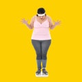 Overweight Asian woman looking shocked to see the weight on the scale Royalty Free Stock Photo