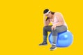 Overweight Asian woman sitting on a gym ball looking bored