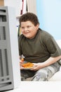 Overweight Boy With Carrot Sticks In Front Of Television