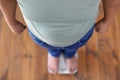 Overweight boy standing on floor scales indoors Royalty Free Stock Photo