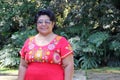 Overweight brunette Latina adult woman in her 50s is happy and proud of her roots wearing traditional Mexican embroidered dress