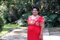 Overweight brunette Latina adult woman in her 50s is happy and proud of her roots wearing traditional Mexican embroidered dress