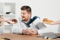 overweight businessman choosing donuts or hamburger with french fries Royalty Free Stock Photo