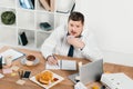 overweight businessman eating donuts, hamburger and french fries while wokring Royalty Free Stock Photo