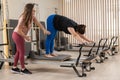 Overweight caucasian woman doing pilates exercises on reformer with personal trainer.