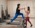 Overweight caucasian woman doing pilates exercises on reformer with personal trainer. Royalty Free Stock Photo