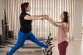 Overweight caucasian woman doing pilates exercises on reformer with personal trainer. Royalty Free Stock Photo