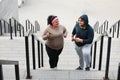 Overweight couple running up stairs together