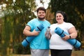Overweight couple wearing sportswear with mats