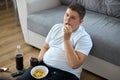 Overweight fat boy eat junk food while watching tv alone at home Royalty Free Stock Photo