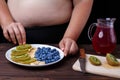 Overweight fat woman making fruit plate. Healthy tasty low-calor Royalty Free Stock Photo