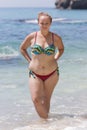 Overweight female person in bikini posing with arms akimbo